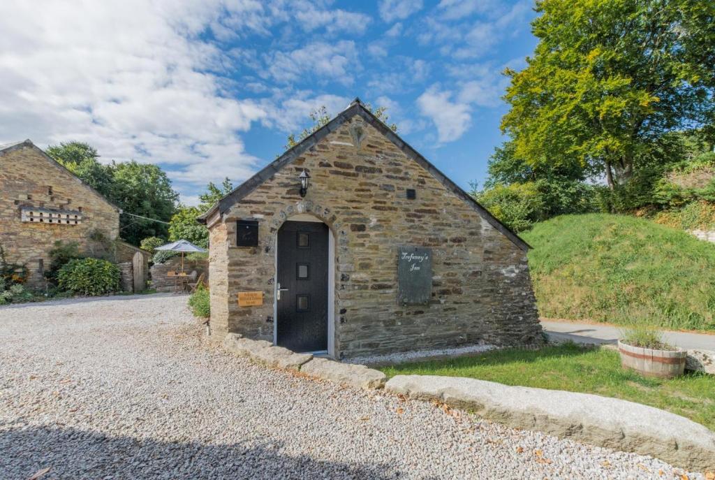an old stone building with a door on a gravel road at 1 Bed in Duloe oc-l30057 in Duloe