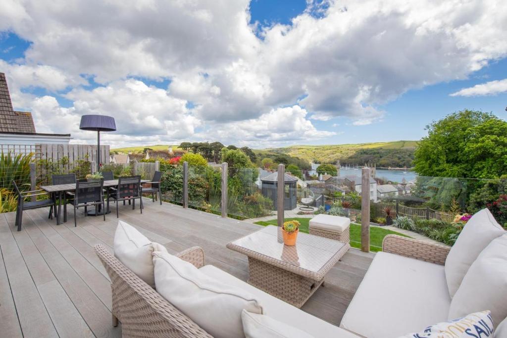 a patio with couches and a table on a deck at 3 Bed in Fowey oc-tidewa in Fowey