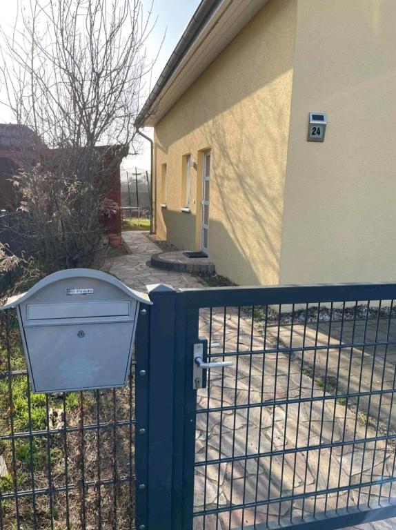 a fence with a trash can next to a building at Sonniges Zimmer im Einfamilienhaus in Berlin