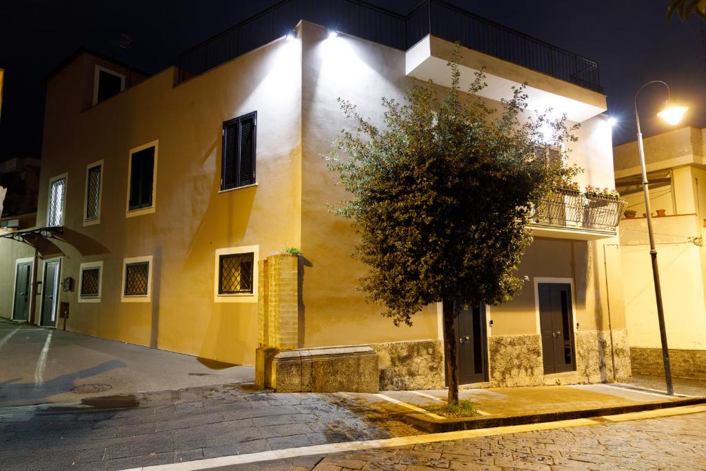 a yellow building with a tree in front of it at B&B Bifulco Boutique Rooms in Ottaviano
