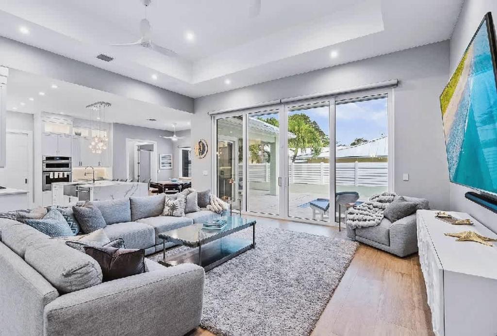 ein Wohnzimmer mit zwei Sofas und einem Tisch in der Unterkunft Spacious Three Bedroom Lakeside Home with Relaxed Coastal Comfort in Palm Beach Shores