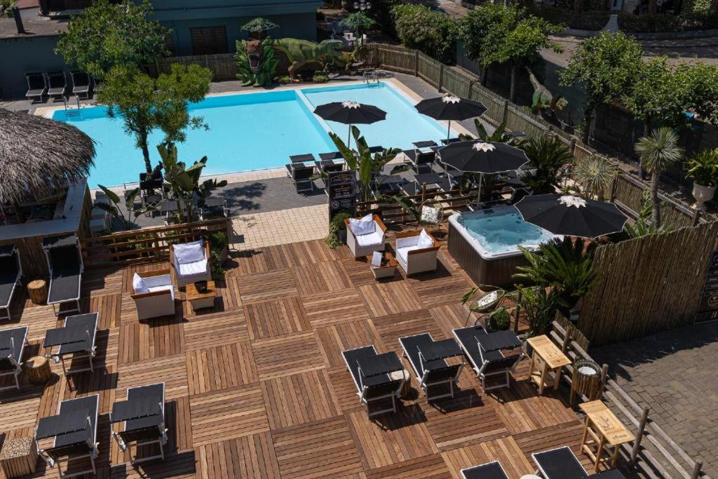 una vista dall'alto di una piscina con sedie e ombrelloni di CASA MAJOR Hotel & Appartamenti CERVIA a Cervia