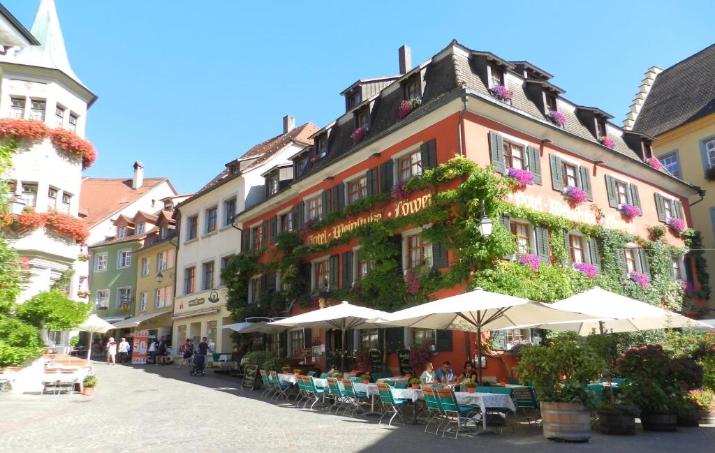 een straat met tafels en stoelen voor een gebouw bij Hotel Löwen-Weinstube in Meersburg