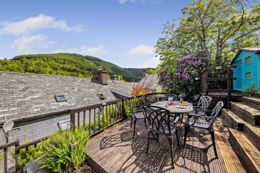 een terras met een tafel en stoelen op een dek bij 3 Bed in Machynlleth oc-bow43 in Corris