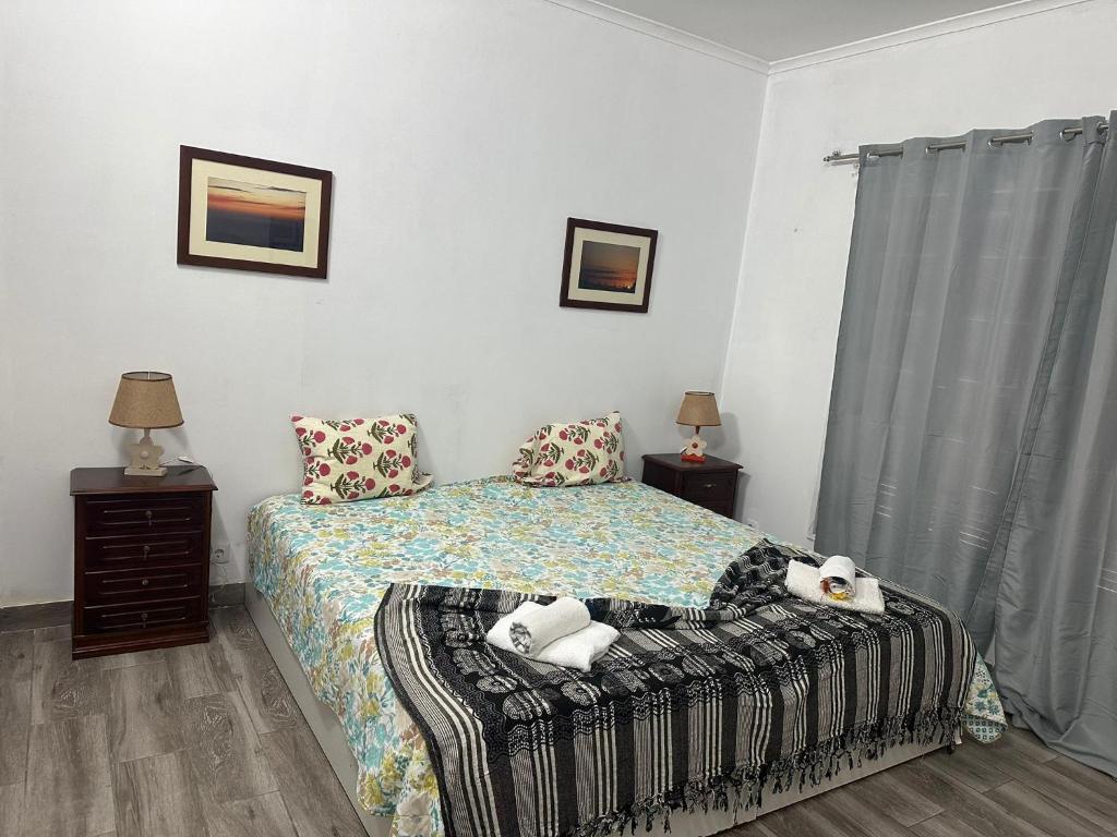 a bedroom with a bed with two towels on it at Micaelense Guest House in Ponta Delgada