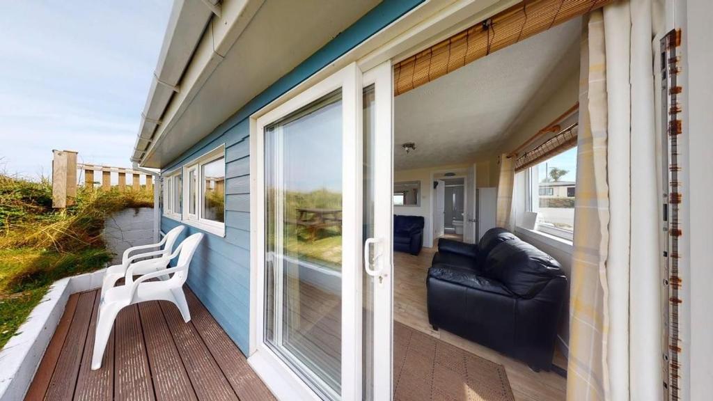 a porch with a couch and a chair on a house at C37 Jupiter, Riviere Towans in Hayle