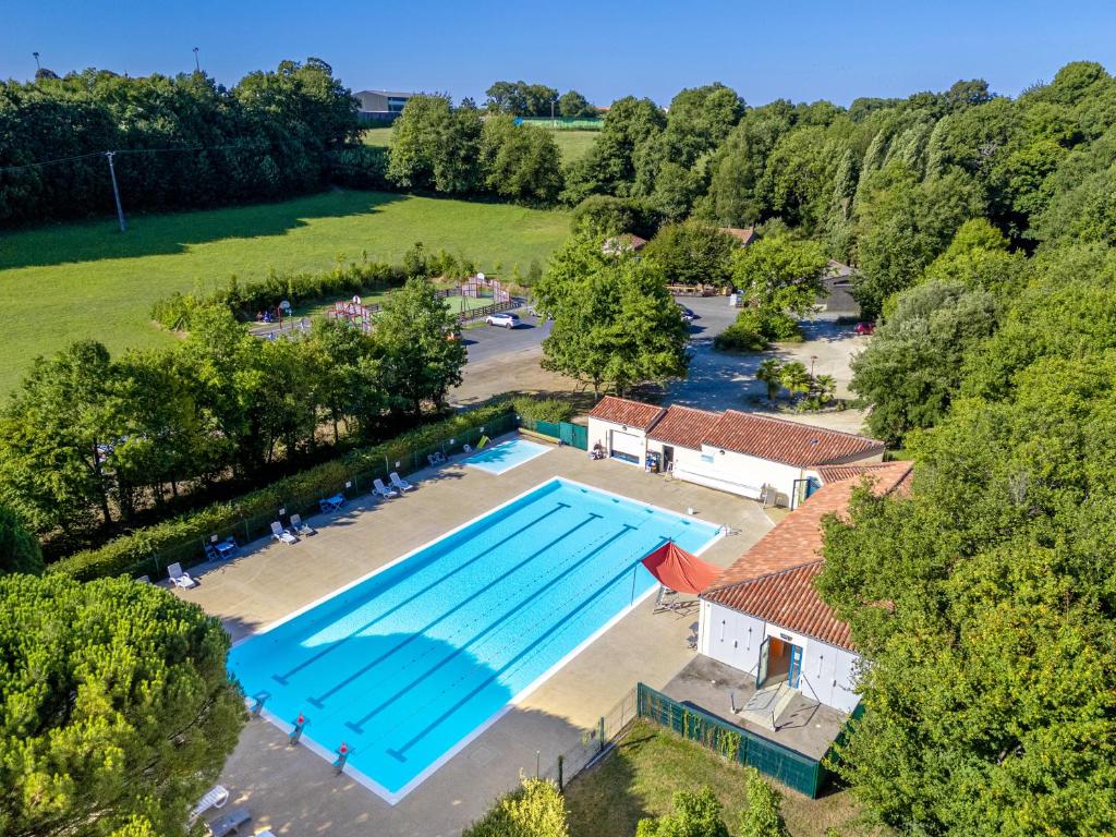 - une vue sur la grande piscine située dans un parc dans l'établissement Camping Capfun La Bretèche, aux Épesses