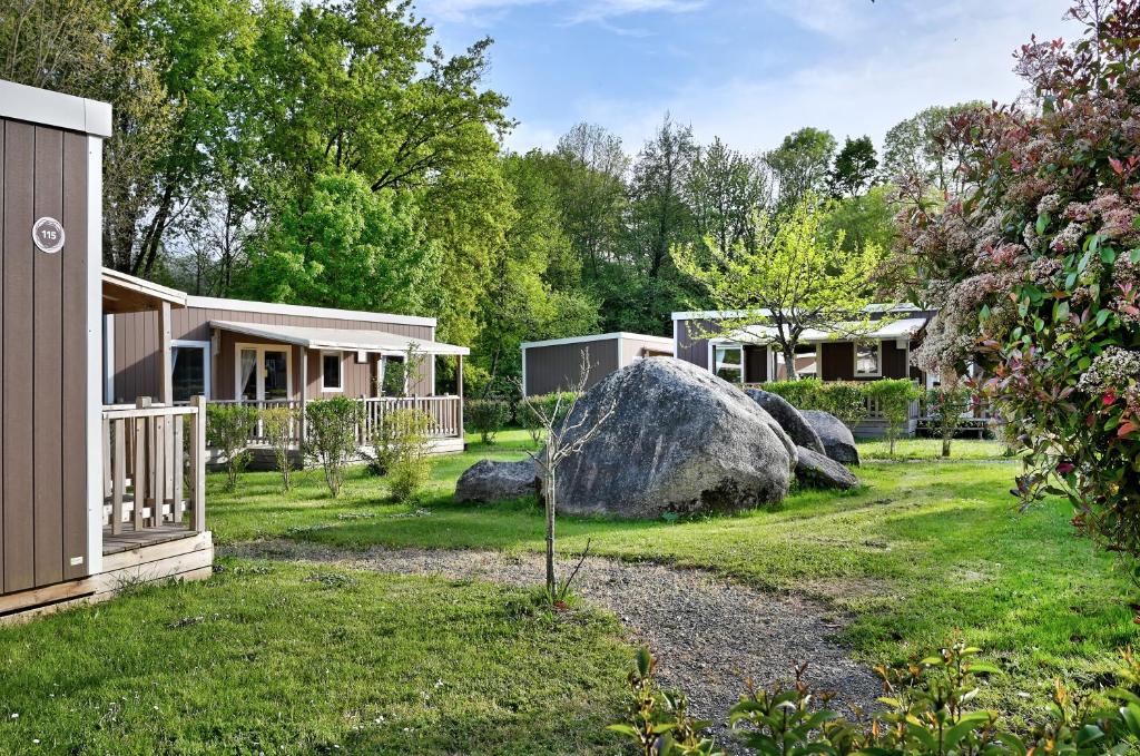 une maison avec une cour en pierre dans l'établissement Camping Capfun La Bretèche, aux Épesses