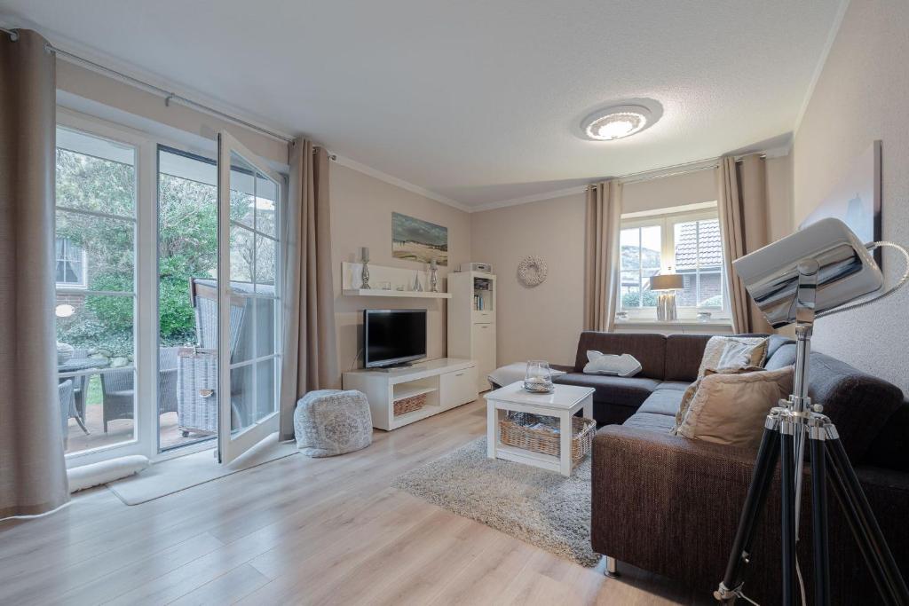 a living room with a couch and a tv at DünenZeit in List