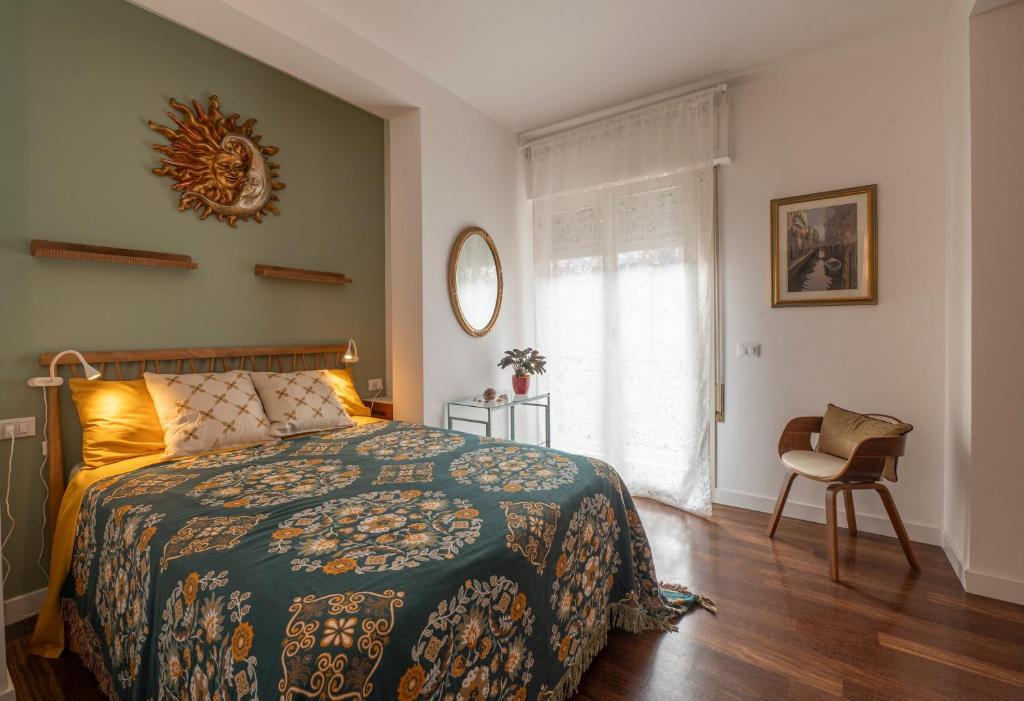 een slaapkamer met een bed, een stoel en een raam bij Apartment Sun&Moon in Venice in Mestre