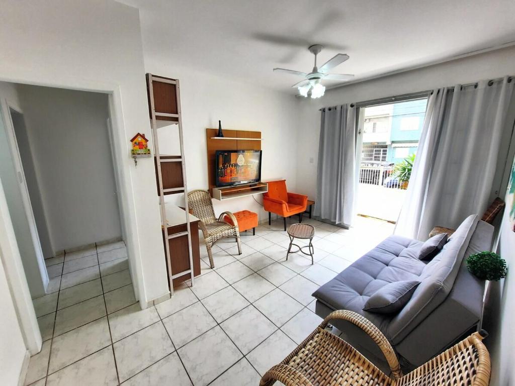 ein Wohnzimmer mit Sofa und Fernseher in der Unterkunft Apartamento na Sepé em Capão da canoa in Capão da Canoa