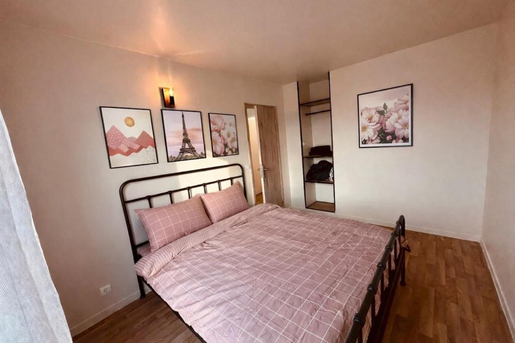 a bedroom with a bed with a pink blanket at Modern and quiet apartment in Cergy