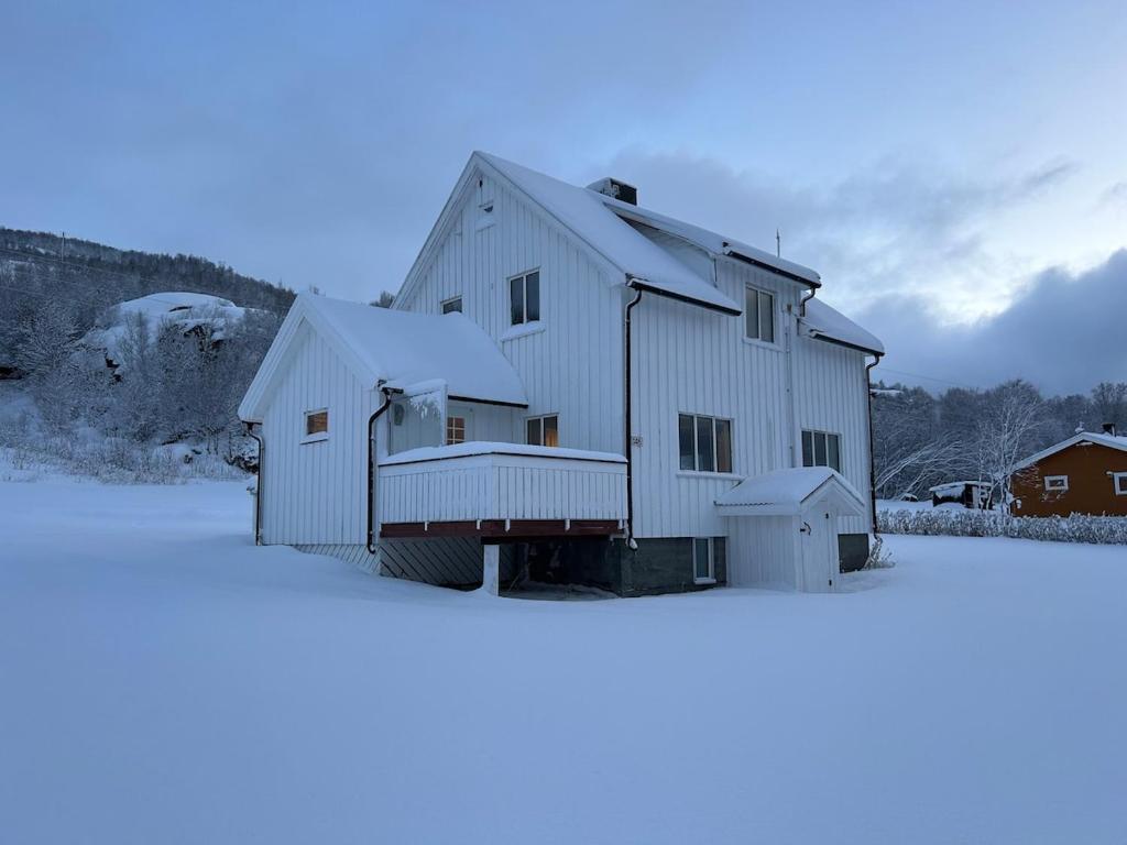 una grande casa bianca con la neve sopra di Mikkelsby house by Altafjord ad Alta