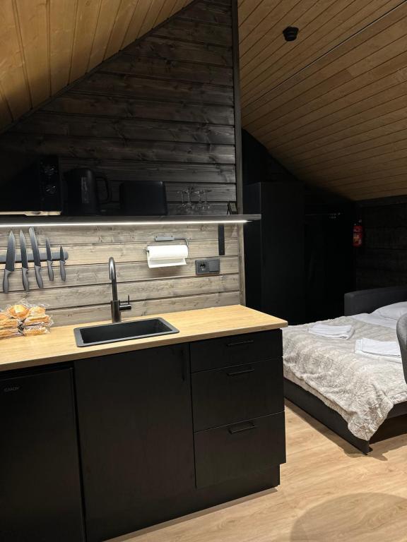 Una cocina con fregadero y una cama en una habitación. en Shaman Village - Resort & Glass Igloos, en Rovaniemi