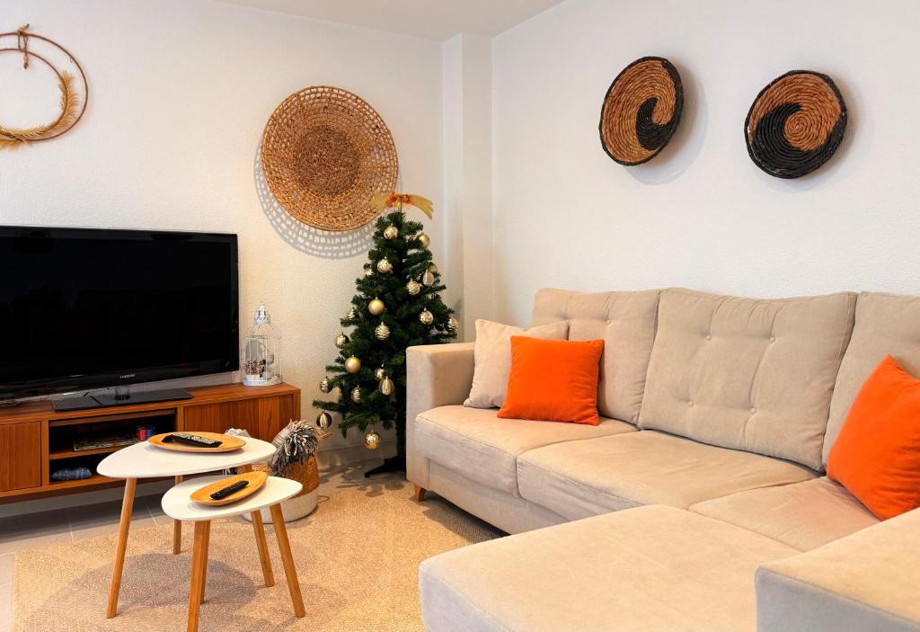 a living room with a white couch and a christmas tree at Apartamento con terraza en Mogro Playa de Usil in Mogro
