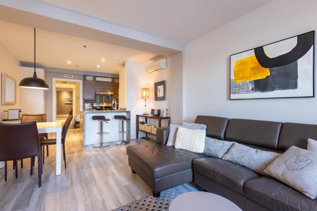 a living room with a couch and a dining room at Les Immeubles Charlevoix - Le 1175 in Quebec City