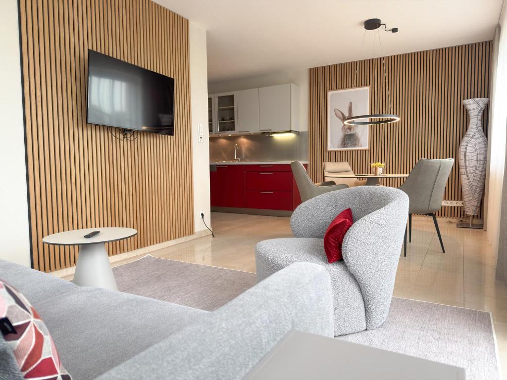 a living room with a couch and a tv on a wall at "SONNTAGSKIND" - 2-Zimmer-Apartment mit Terrasse und Privatgarten in Kraiham