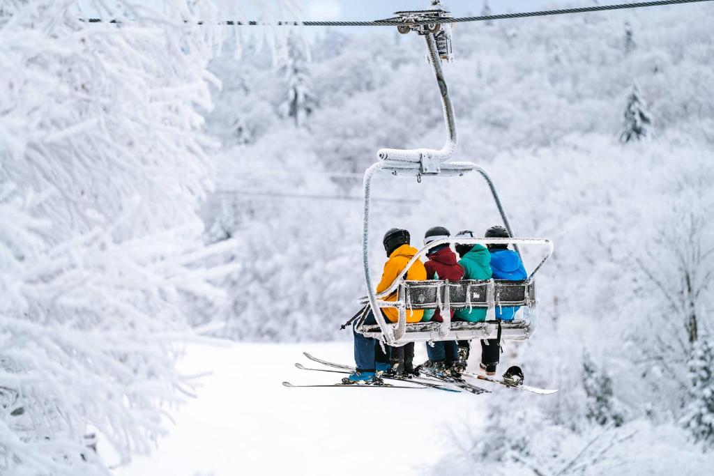 een groep mensen die in de sneeuw op een skilift rijden bij Le Saint-Laurent in Petite-Rivière-Saint-François