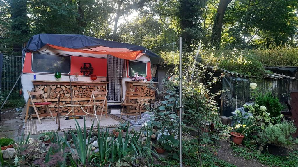 a red caravan with a tent in a garden at Tinyhaus am Flughafen, der DLR und ESA in Cologne