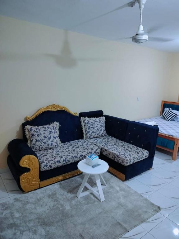 a living room with a blue couch and a white table at Mwangaza studios in Mombasa