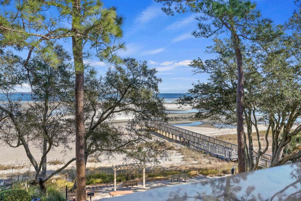 een uitzicht op een strand met bomen en de oceaan bij Unspoiled Beachfront Villa Sunrises from Balcony in Hilton Head Island
