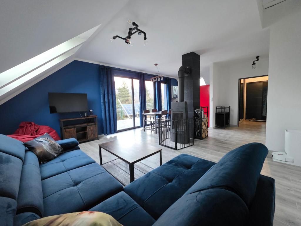 ein Wohnzimmer mit einem blauen Sofa und einem Tisch in der Unterkunft Domki Przystankowe 4 żywioły in Smerek