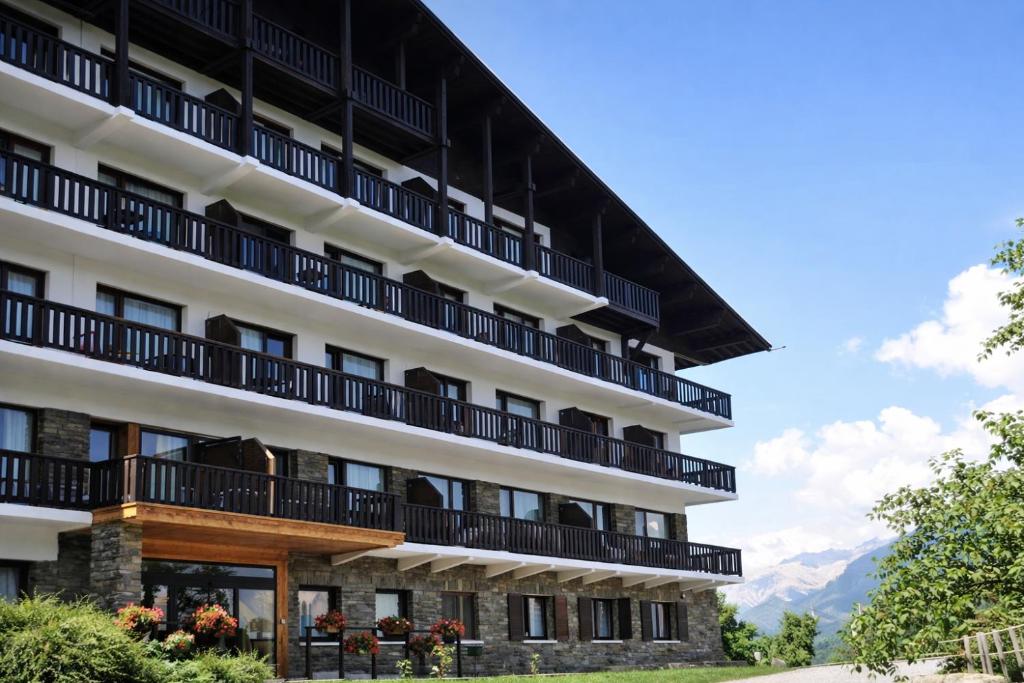 Résidence & Spa La Grande Cordée - Combloux في كومبلو: فندق فيه بلكونات وجبال في الخلف