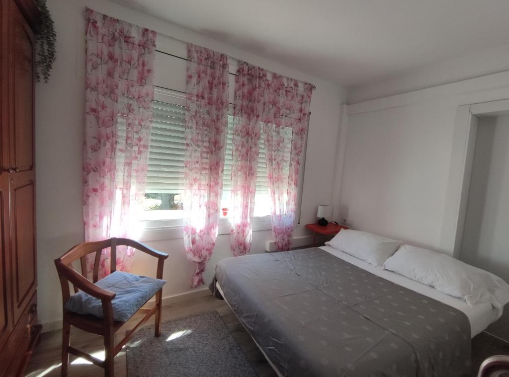 ein Schlafzimmer mit einem Bett, einem Stuhl und einem Fenster in der Unterkunft Suite de invitados independiente in Cerdanyola del Valles