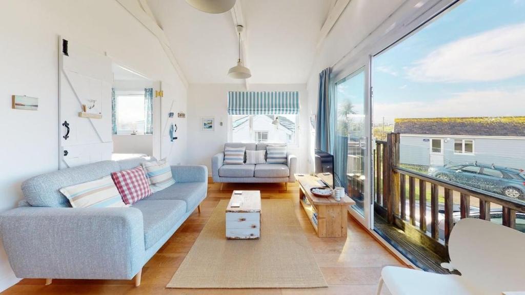 a living room with a couch and a large window at D22 Sandelite, Riviere Towans in Hayle