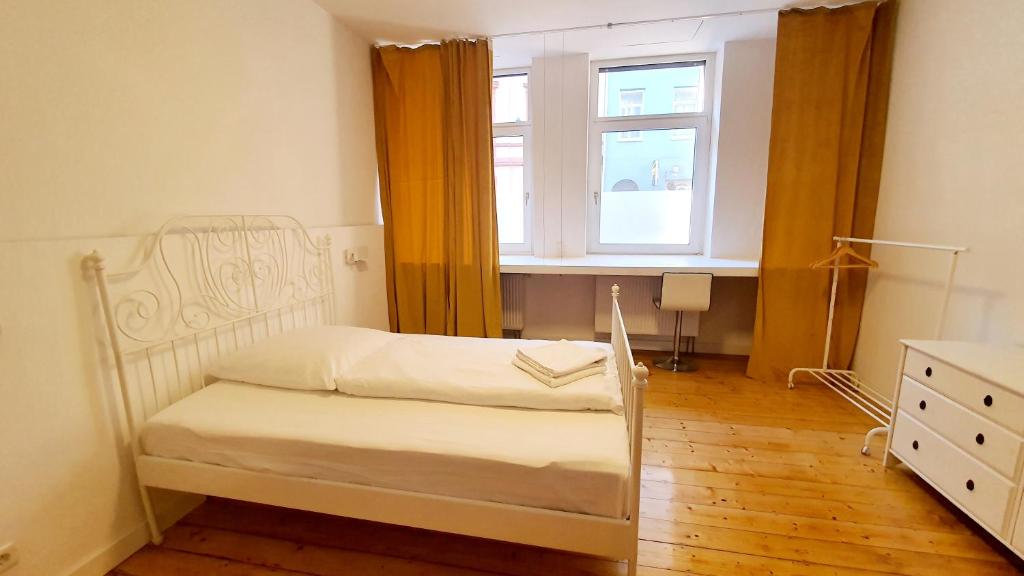 una piccola camera da letto con un letto e una finestra di Zimmer im Erdgeschoss a Mannheim