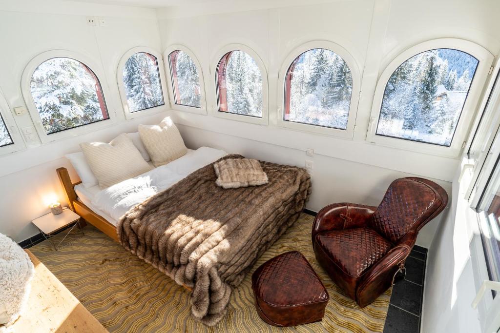 een slaapkamer met een bed, een bank en ramen bij Edelweiss Schlosswohnung in Flims