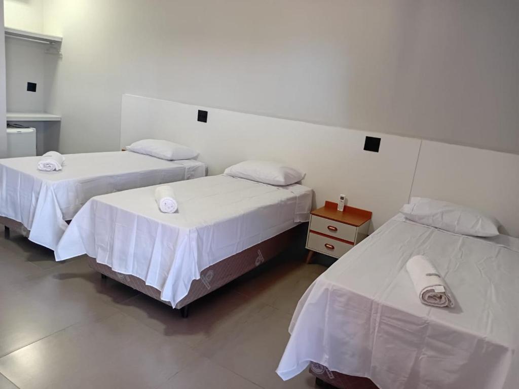 due letti in una stanza con pareti bianche di Hotel Tamboril a Barra Bonita