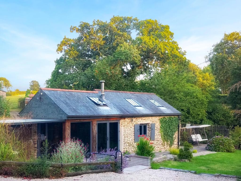 ein Cottage aus Stein mit einem Wintergarten im Garten in der Unterkunft Little Penquite in Landrake