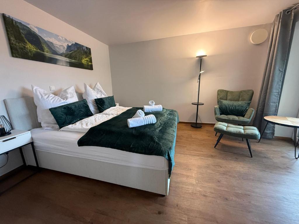 een slaapkamer met een bed en een stoel erin bij Kurpark Suites Bad Aibling in Bad Aibling