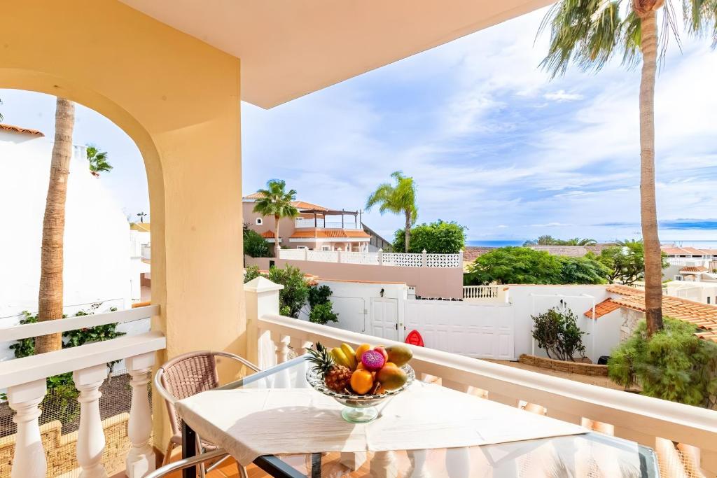 un tavolo su un balcone con un cesto di frutta di Spacious Villa Victoria Heated Pool a Callao Salvaje