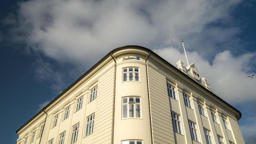 a building with a flag on the top of it at Radisson Blu 1919 Hotel, Reykjavík in Reykjavík