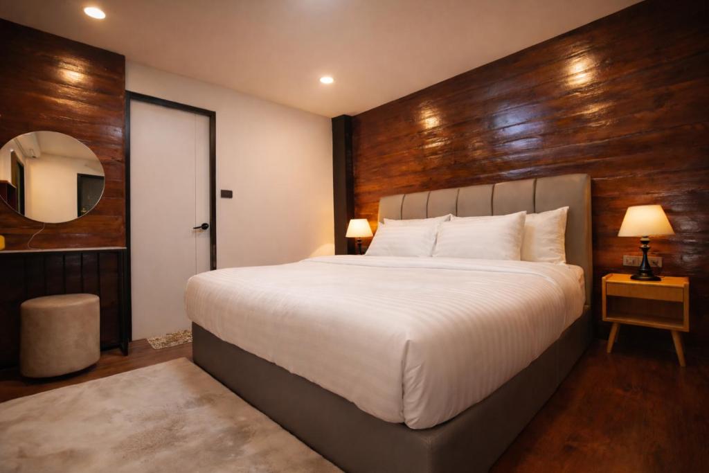 パーイにあるANNKAMii INNの木製の壁と大きなベッドのある寝室