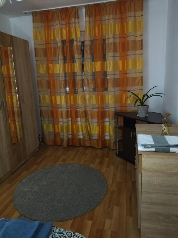a living room with an orange curtain and a table at La Han in Făgăraş