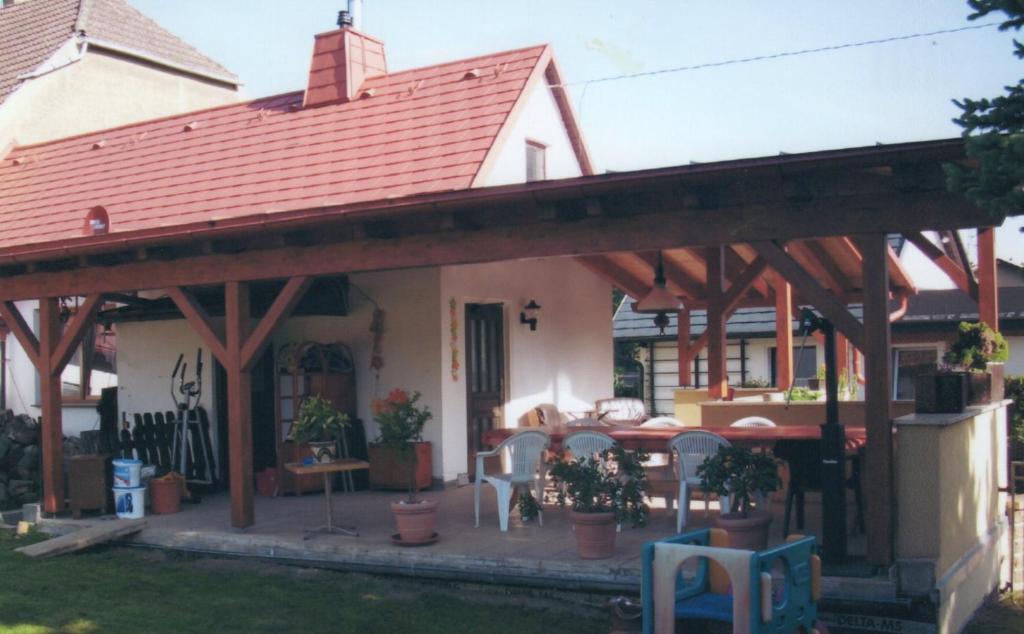 een huis met een grote houten pergola bij Ferienwohnung bei Familie Keil in Colditz