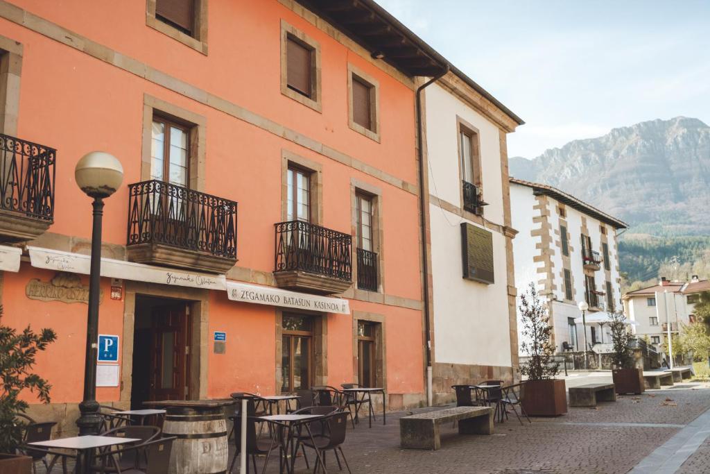 eine Straße mit Tischen und Stühlen vor einem Gebäude in der Unterkunft Ostatu de zegama in Zegama