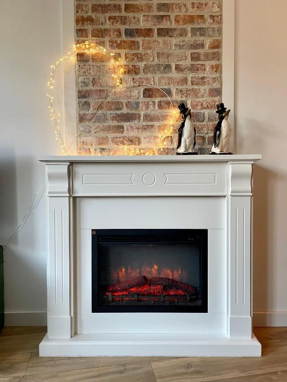 a fireplace with a white mantel and a brick wall at 123 Honfleur in Honfleur