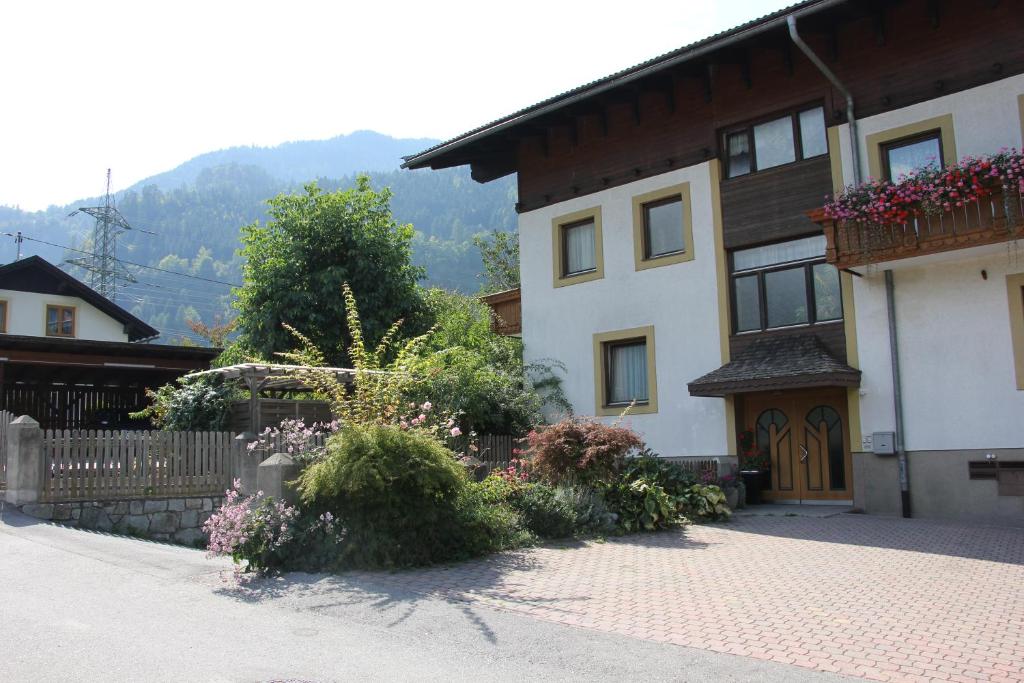 dom z płotem i kwiatami przed nim w obiekcie Haus Egger w mieście Oberdrauburg