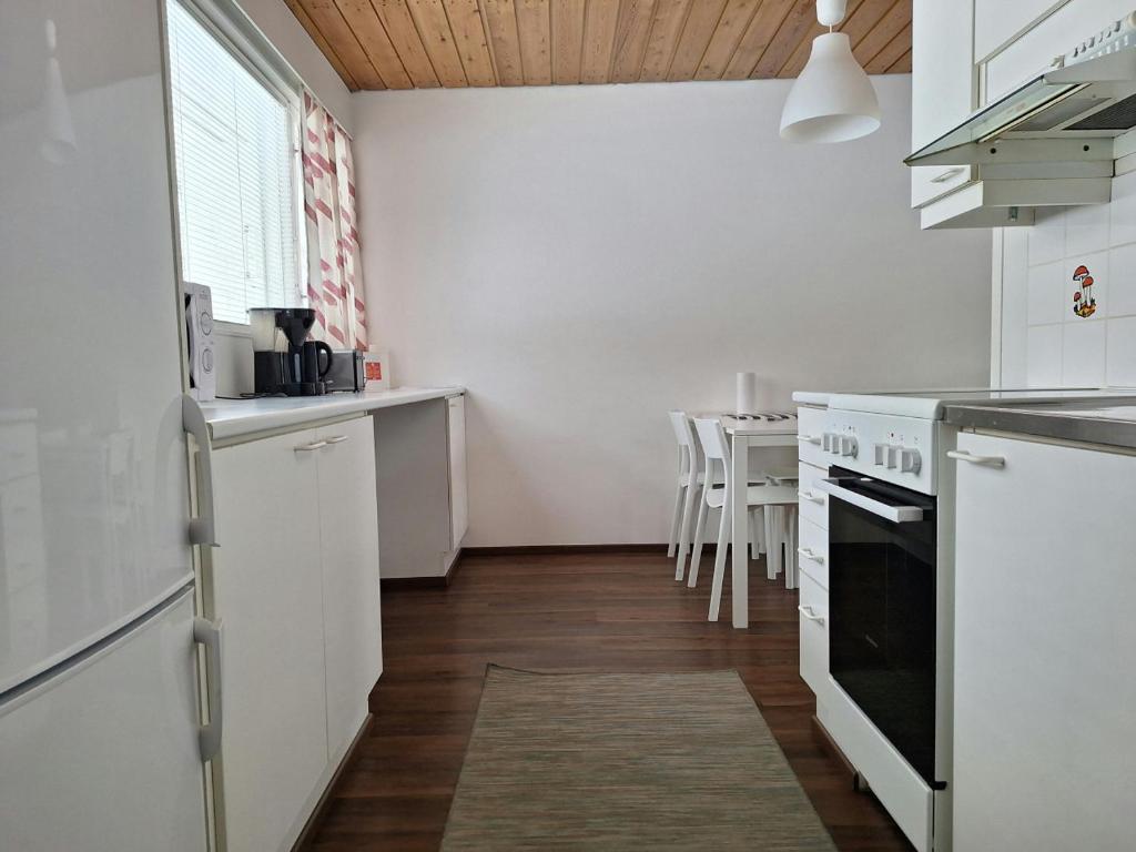 a kitchen with white appliances and a table with chairs at Spacious Apartment for 5 in Sodankylä