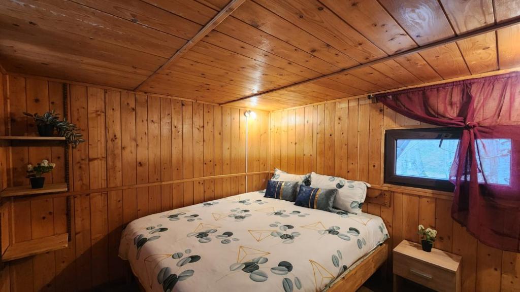 una camera da letto con un letto in una cabina di legno di Cabana Pinolera a Boga