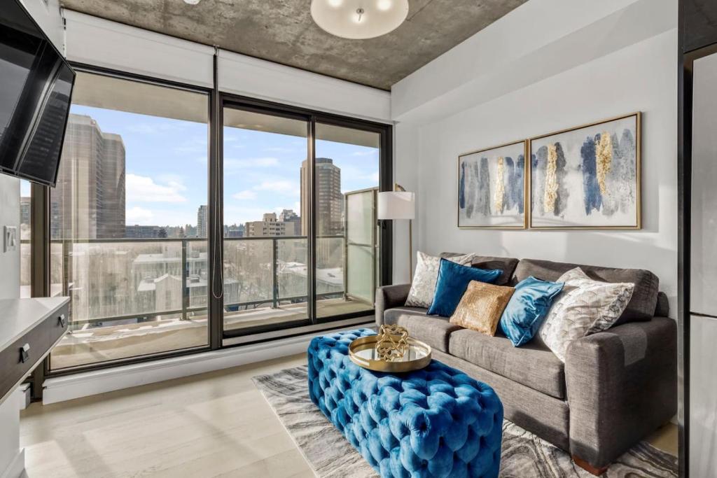 a living room with a couch and a large window at Spacious and Stylish Modern Condo in Calgary in Calgary