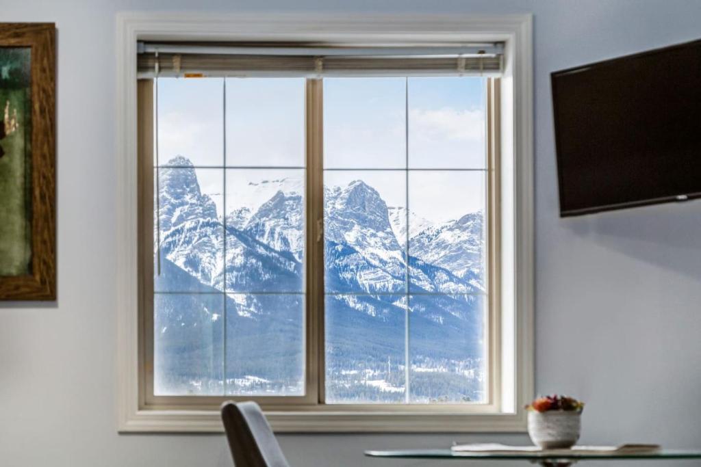 a window with a view of a snow covered mountain at Cozy Mountain View Condo Close to DT Canmore in Canmore