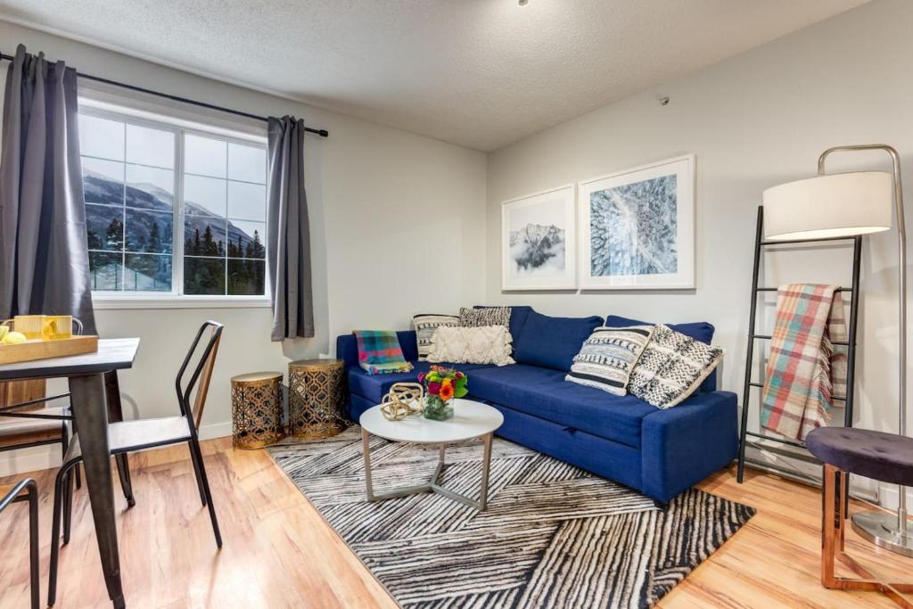 a living room with a blue couch and a table at Delightful 2BR Mountain Escape in Canmore in Canmore