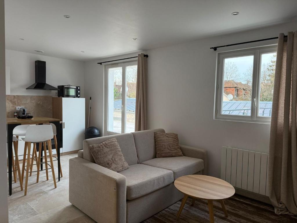 ein Wohnzimmer mit Sofa und Tisch in der Unterkunft Le prestige - Charmant T2 neuf avec Terrasse in Évreux