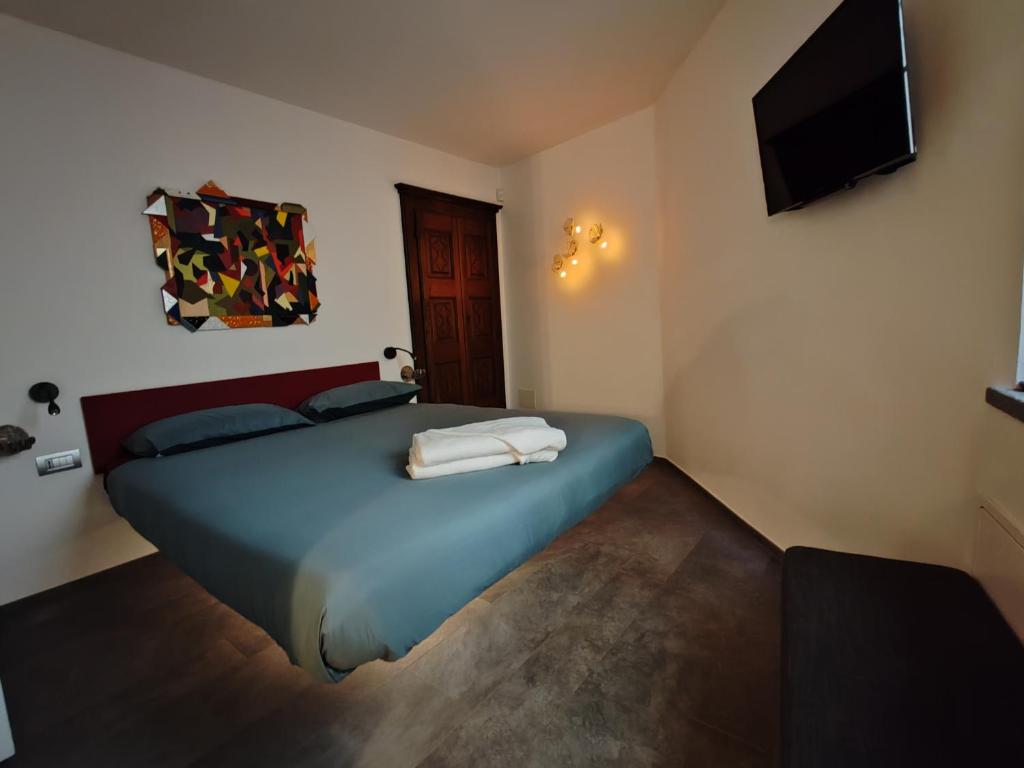 una camera con letto blu e TV a schermo piatto di Maison Josephine ad Aosta