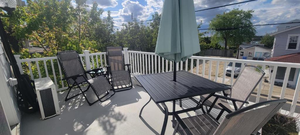 eine Terrasse mit Stühlen und einem Tisch mit einem Sonnenschirm in der Unterkunft Private 2 Home Haven - Walk 2 Beach, Free Parking in Ventnor City